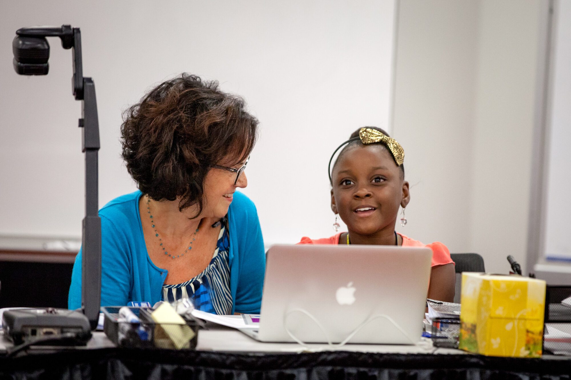 Deborah Loewenberg Ball working with a young girl at a desk with a laptop