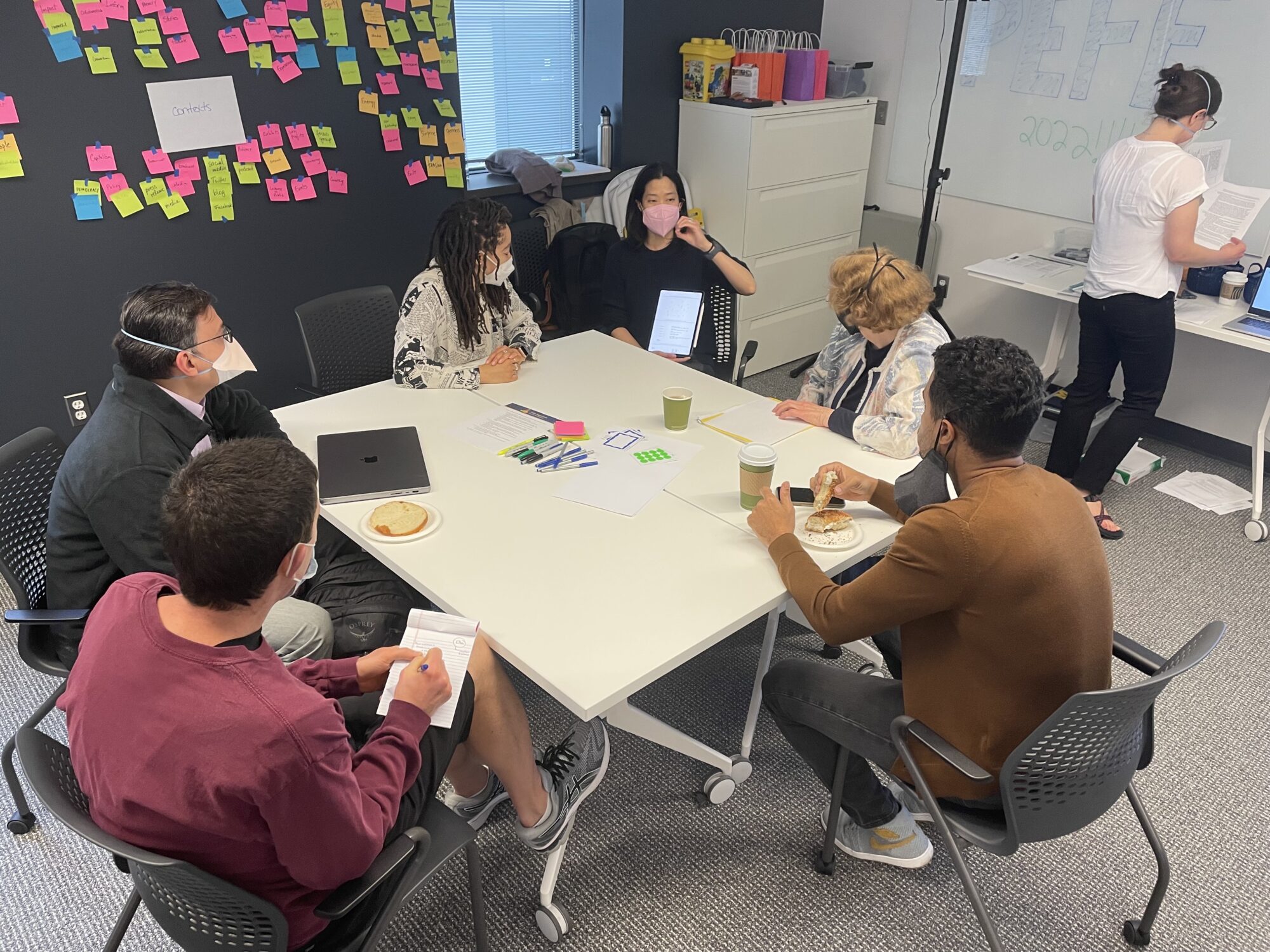 group of PEFF fellows sitting around a work table with laptops and post its