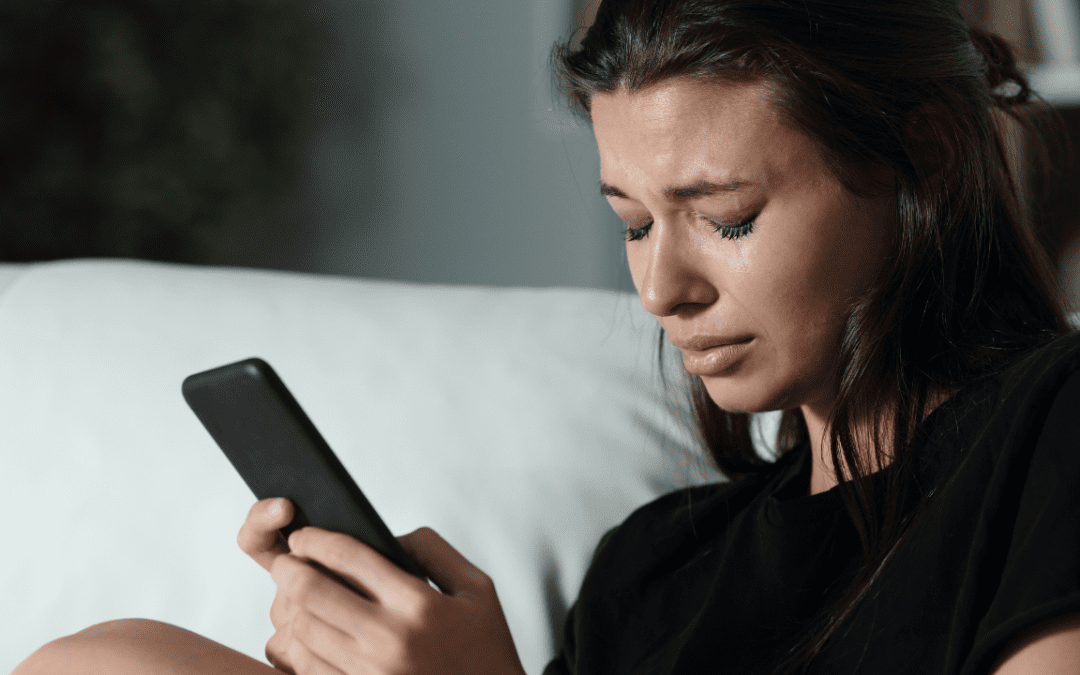 Female teen texting and crying.