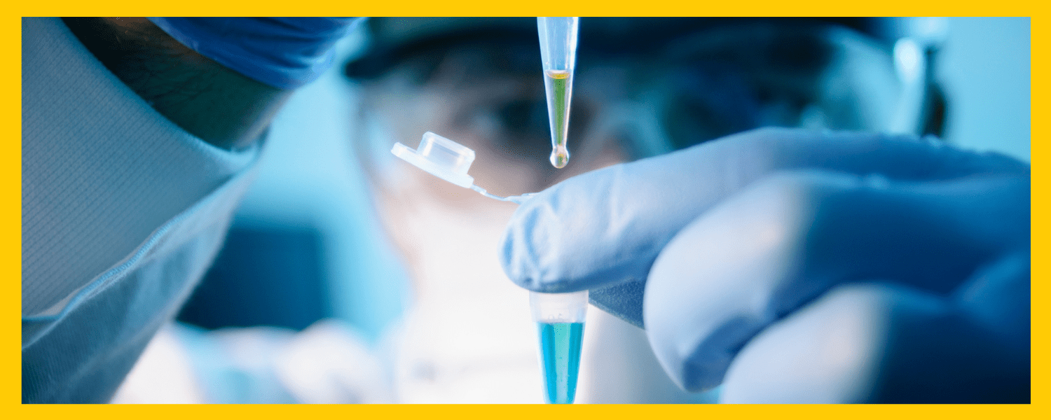 photo of a researcher in glasses and gloves looking closely at a vial