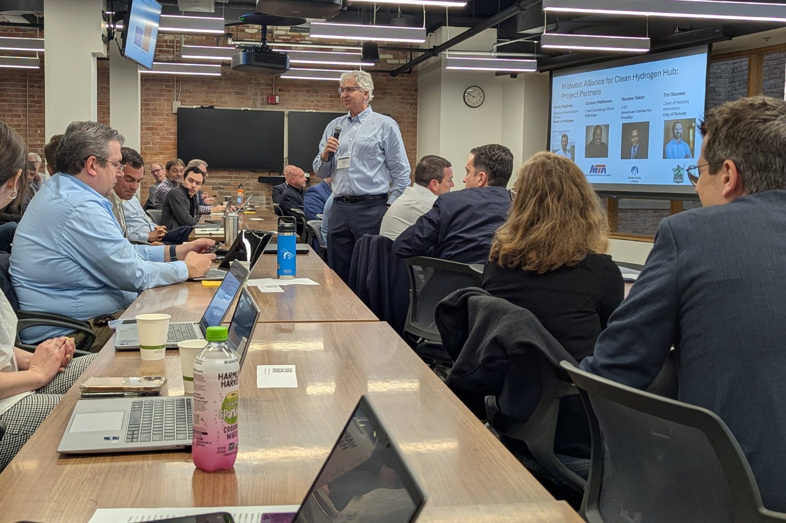Greg Keoleian stands with a microphone, speaking to attendees of the MI Hydrogen workshop.