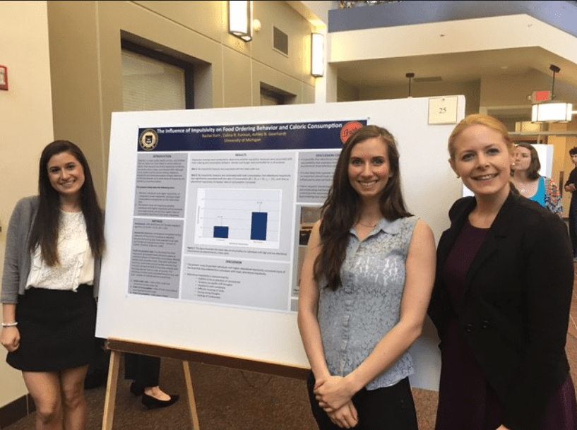 photo of Ashely Geardhart with students at a poster session