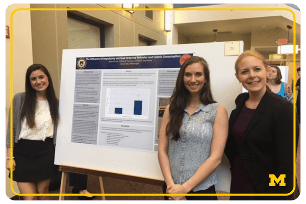 impact stories - web buttons (2) Ashley Geardhart and two students standing in front of a poster board