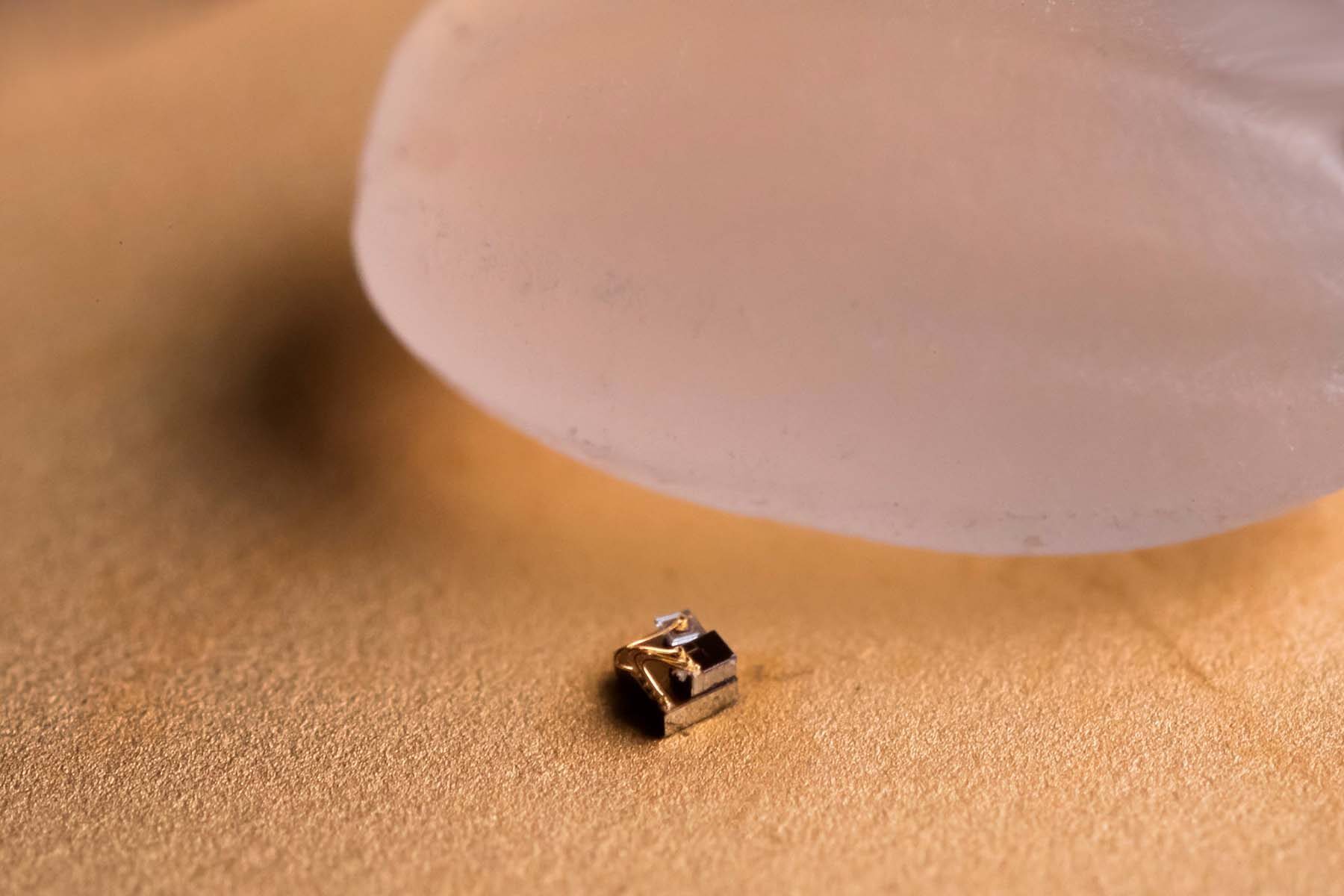</p>
<p>The Michigan Micro Mote (M3) computer next to a grain of rice for scale. 