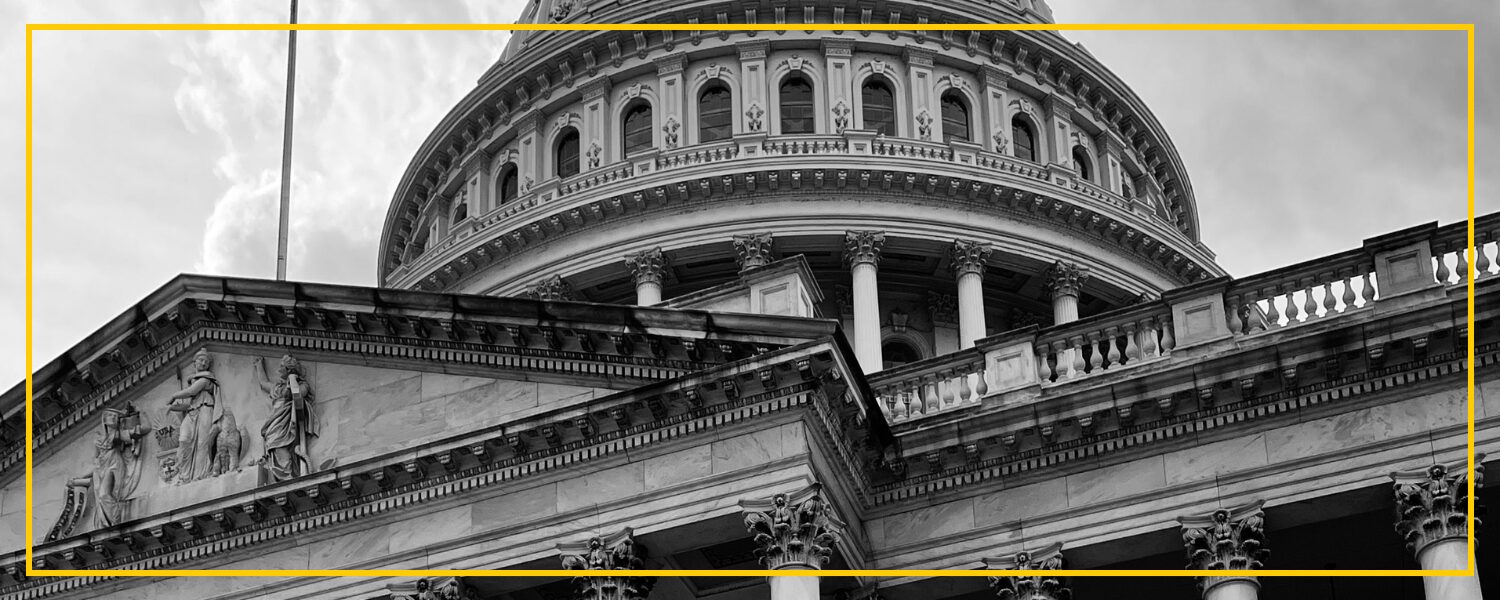 black and white photo of an upward view of part of the U.S. capital building