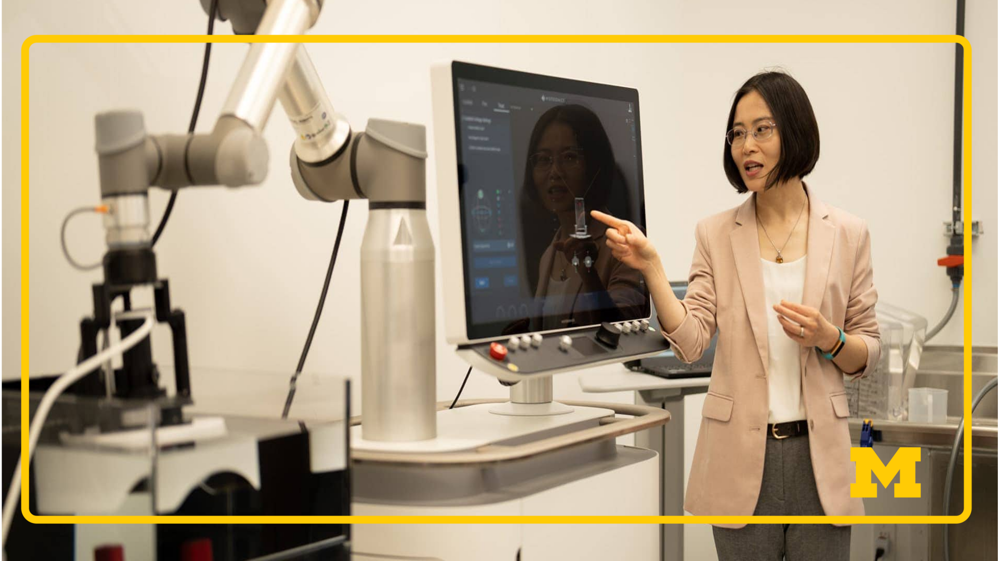 HistoSonics Person in professional attire interacting with a robotic medical system and touchscreen monitor in laboratory or clinical setting.