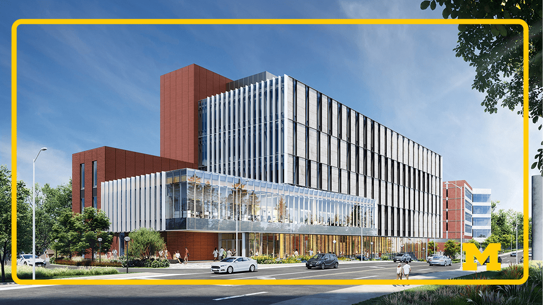New College of Pharmacy Building Street-level view of a modern multi-story building with glass walls and vertical metal fins, red brick sections, and trees along the sidewalk; cars drive past and a few pedestrians walk near the entrance under a clear blue sky.