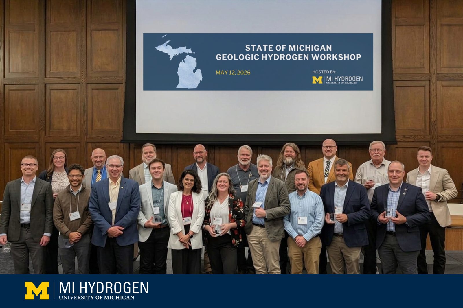 A group poses in front of a screen that reads MI Hydrogen Geologic Workshop