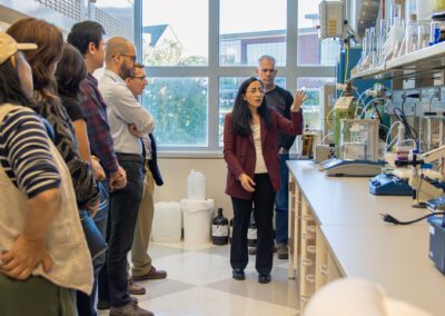 Hala Abou Assi, oligonucleotide synthesis scientist in the Nucleic Acids Therapeutics Core, provides U-M researchers with a tour of the core’s new space. (Photo by Rajani Arora, Life Sciences Institute)